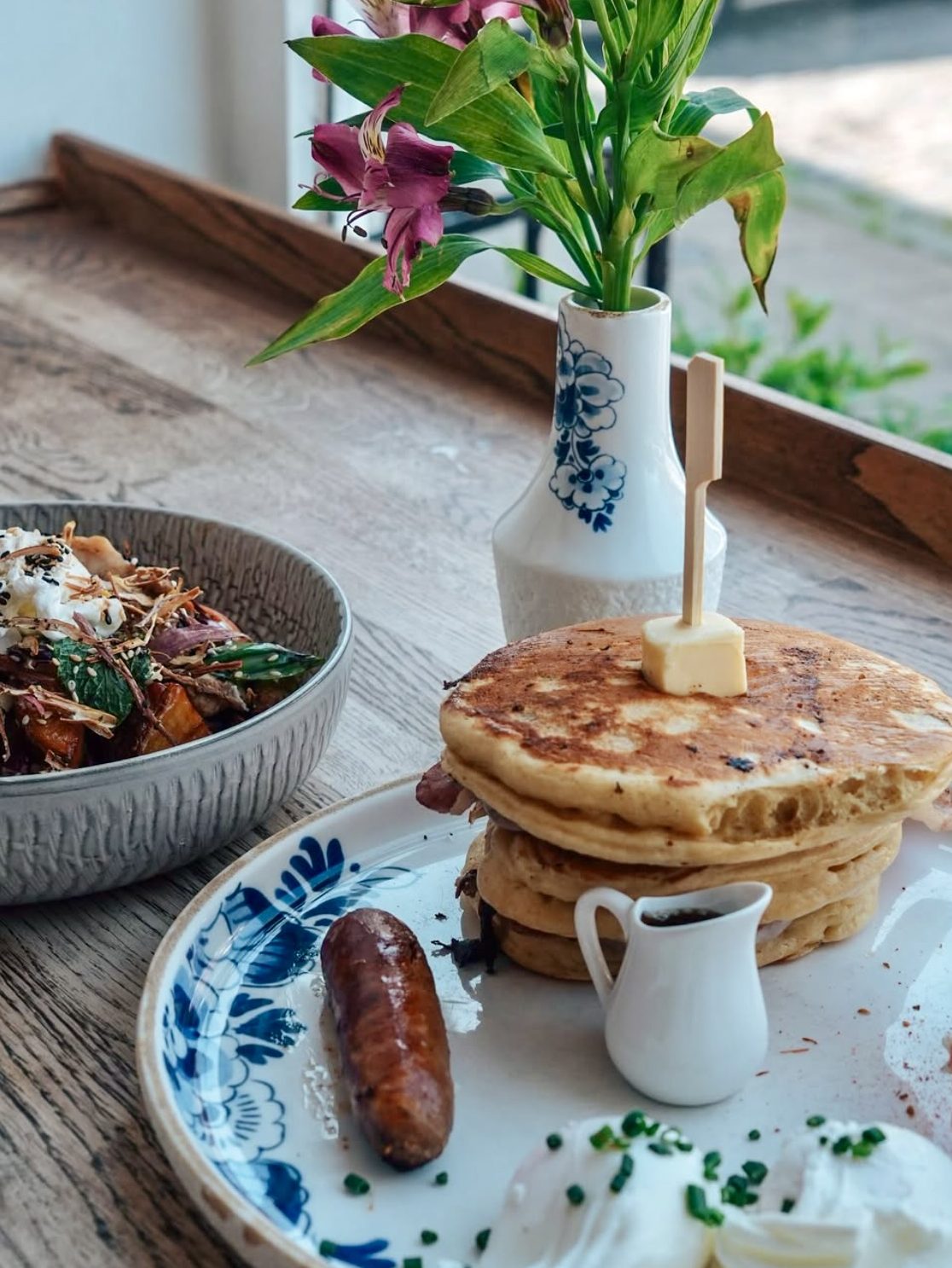 Brunch at Greenwoods in Edinburgh featuring a sesame sunrise bowl and pancake breakfast stack by the window