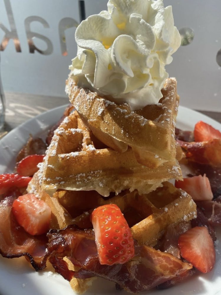 Sweet and savoury waffle stack with crispy bacon, strawberries and cream at Papii in Edinburgh