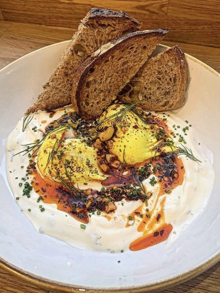Turkish eggs with creamy herb yoghurt, chilli oil and bread at Society Bar & Kitchen in Edinburgh