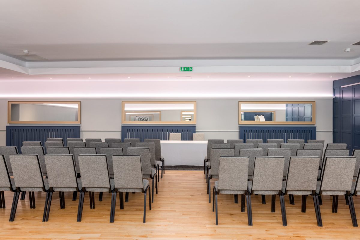 Function room set up theatre-style with rows of grey chairs facing a top table at 28 York Place.